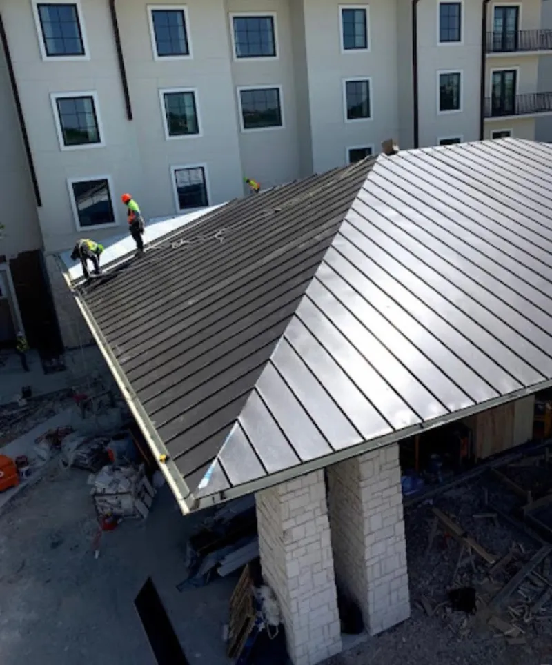 Crew installing standing seam metal roof panels on a commercial project in Ocala